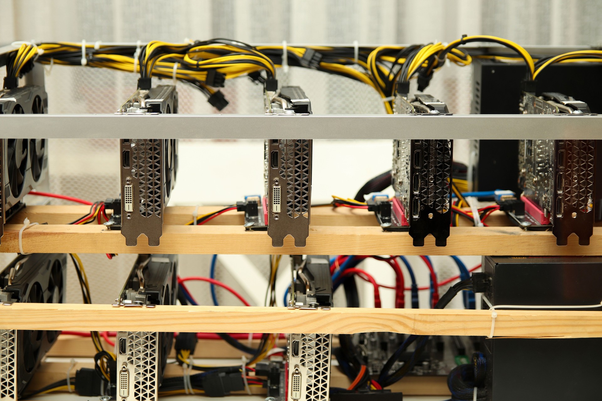 a home-based cryptocurrency mining farm, featuring multiple video cards arranged for efficient mining operations. The setup includes high-performance GPUs, wires, and cooling systems